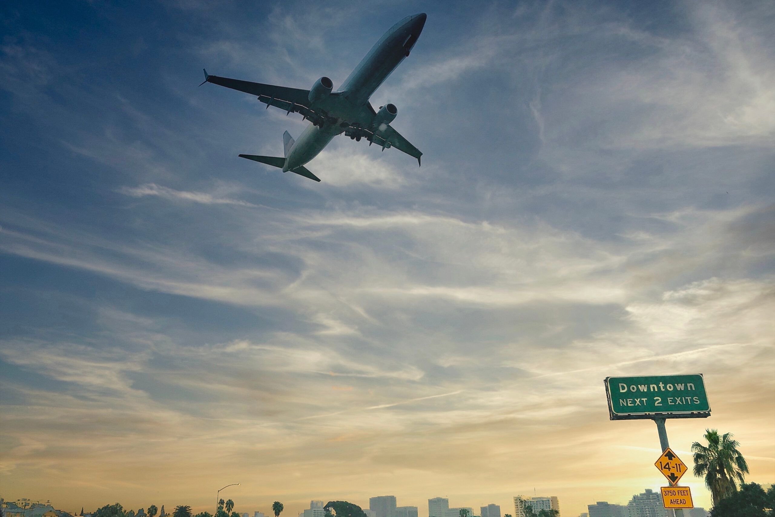 Airplane flying over downtown Los Angeles, representing why some people leave Los Angeles for private rehab abroad and seek treatment in more secluded international settings.