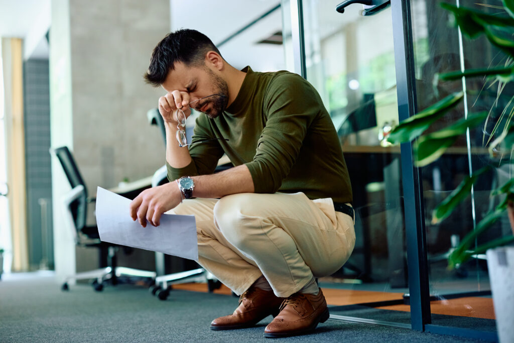 A stressed professional showing signs of high-functioning addiction while struggling privately at work