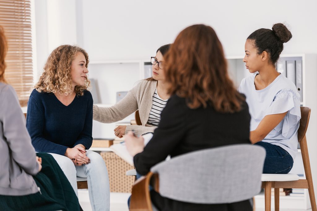 Family members participating in a supportive discussion while learning how to stage an intervention for addiction.